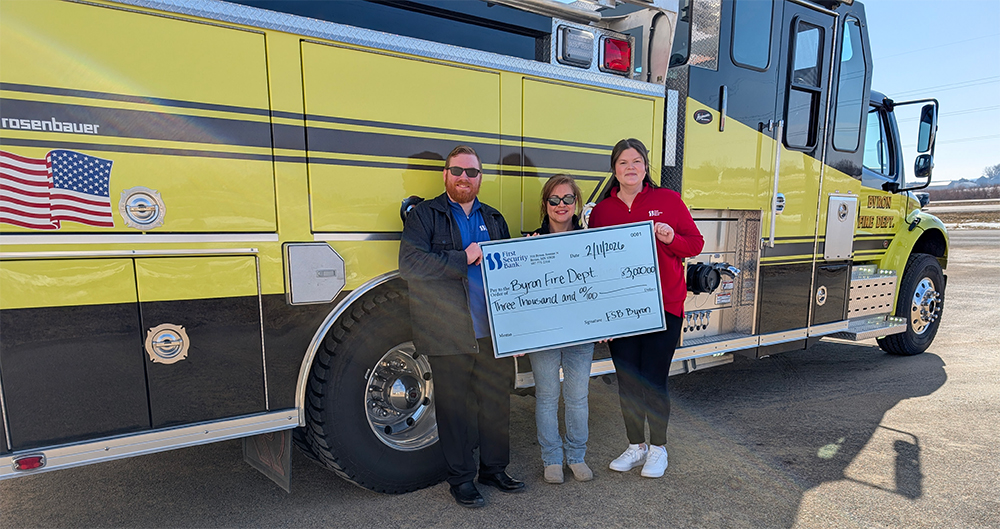 FSB employees with Byron volunteer firefighter presenting check