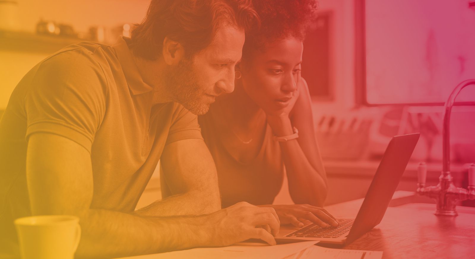 Couple in kitchen on laptop